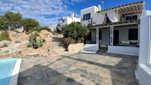 a house with a swimming pool in front of it at Cozy Summer House in Mikonos