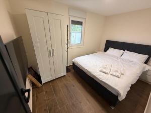 a bedroom with a bed with white sheets and a window at AdDrinum in Gornja Koviljača +6 photos