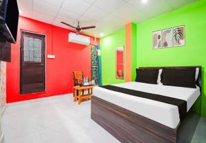a bedroom with a green and red wall at Hotel Pink City& Banquet in Dīgha