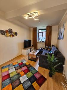 a living room with a couch and a colorful rug at Ferienwohnung Stella in Zülpich