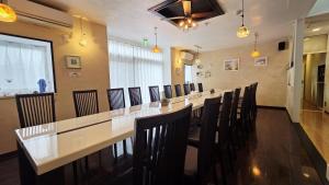ein langes Esszimmer mit einem langen Tisch und Stühlen in der Unterkunft Atria CHIKURA in Minamiboso