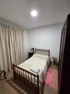 a bedroom with a bed with a wooden frame at RECANTO da VONINHA in Castelo de Paiva