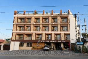 a building with a car parked in front of it at Hotel Maniratna Premium in Indore