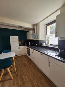 a kitchen with white cabinets and a table and a window at Ferienwohnung Stella in Zülpich