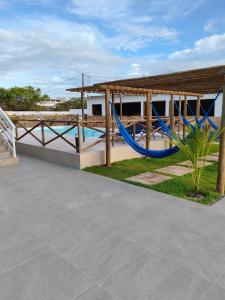 a playground with a blue hammock and a building at Pousada Imperio Azul in Santo Amaro