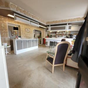 a kitchen with a table and chairs and a counter at Logis Hôtel Le Merle Blanc in Digoin