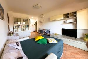 a living room with a bed with pillows on it at NUOVO Alloggio Giardino di Rosy tra Roma EUR e il Mare di Ostia in Vitinia