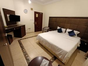 a bedroom with a bed and a desk and a television at الامتياز in Jeddah