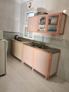 a kitchen with brown cabinets and a sink in it at الامتياز in Jeddah