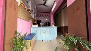 a corridor of a restaurant with a counter and plants at Hotel Akshni Palace in Pūrnia