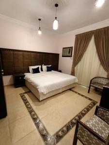 a bedroom with a large white bed and a chair at الامتياز in Jeddah