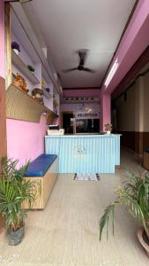 a restaurant with a bar in a room with plants at Hotel Akshni Palace in Pūrnia