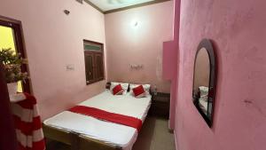 a small pink room with a bed and a mirror at Hotel Akshni Palace in Pūrnia +70 photos