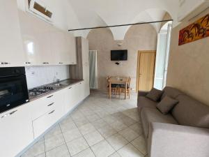 a kitchen and living room with a couch and a table at Garibaldi 39 in Loano
