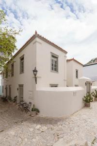 a white house with a courtyard in front of it at Cactus Hydra - Art Apartments in Hydra