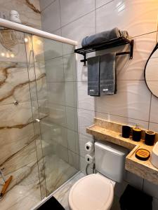 a bathroom with a toilet and a glass shower at Pousada Imperio Azul in Santo Amaro +16 photos