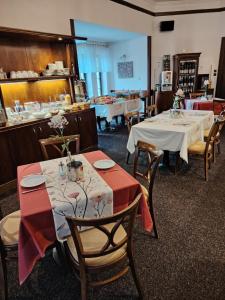 a restaurant with two tables and chairs and a counter at Hotel Veba in Broumov