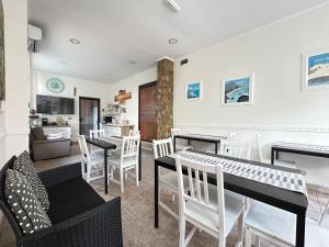 a living room with tables and chairs and a kitchen at Pensione Affittacamere Miriam in Scalea