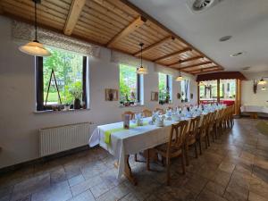 a large dining room with a long table and chairs at Hotel Waldesruh in Lengefeld