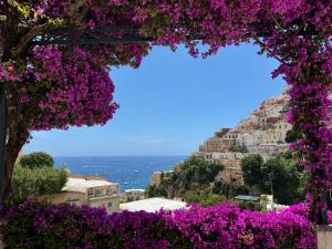 a view of the amalfi coast with purple flowers at Hotel Bougainville in Positano