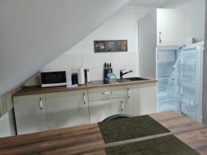a kitchen with white cabinets and a sink and a refrigerator at Aluston in Hannover
