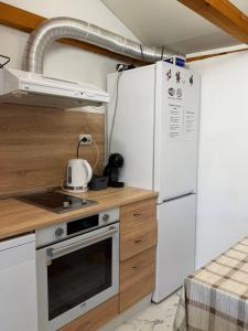 a kitchen with a white refrigerator and a stove at Apart Hotel Lyubimets in Lyubimets