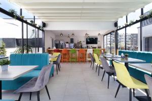 a restaurant with blue and yellow chairs and tables at Bunga Bunga Resort Mamaia Nord in Mamaia Sat/Năvodari