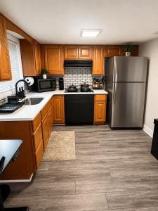 a kitchen with wooden cabinets and a stainless steel refrigerator at King Suite and Sofa Bed Fast WI-FI Easy DC Access in District Heights +10 photos