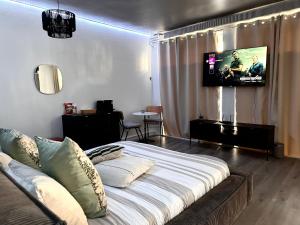 a bedroom with a bed with a tv on the wall at La suite 44 in Le Locle