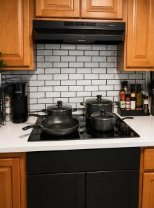 a stove top with three pots on top of it at King Suite and Sofa Bed Fast WI-FI Easy DC Access in District Heights