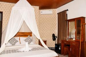 a bedroom with a bed with a mosquito net at Adyara Homestay in Sidemen