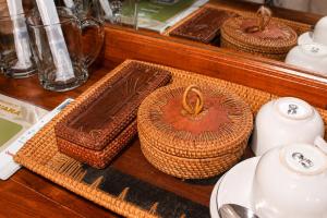a table with baskets and cups and plates on a table at Adyara Homestay in Sidemen