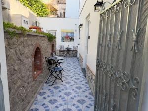 a small alley with a table and chairs on a tile floor at La Piccola Suite in Anacapri