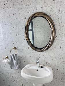 a bathroom with a mirror and a sink at The Snug Spot in Lusaka