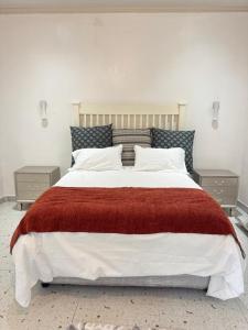 a bedroom with a large bed with a red blanket at The Snug Spot in Lusaka
