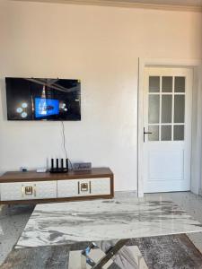 a living room with a table and a tv on the wall at The Snug Spot in Lusaka