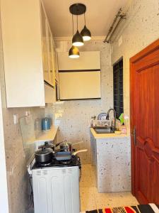 a kitchen with a stove with pots and pans on it at The Snug Spot in Lusaka +3 photos