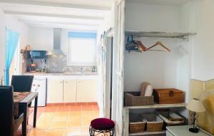 a kitchen with white cabinets and a table at Casira gastenkamers & Casitas, Viñuela, Andalucía in Viñuela