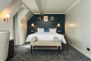 a bedroom with a large bed with blue walls at The Lochalsh Hotel - Isle of Skye in Kyle of Lochalsh