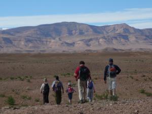 a group of people walking through the desert at Kasbah Abdou in El Kelaa des Mgouna
