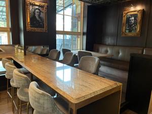 a dining room with tables and chairs and windows at Queens Hotel Belfast in Belfast