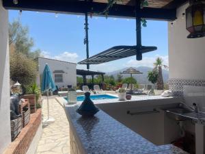 eine Küche mit Spüle und ein Schwimmbad in der Unterkunft Casita Risa in Viñuela