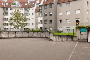 an empty parking lot in front of buildings at The Originals City, Hôtel Le Forum, Strasbourg Nord in Schiltigheim