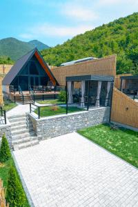 a house with a stone pathway and a building at Zeyzid Glamping Sheki in Sheki
