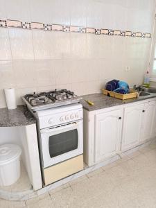 a kitchen with a white stove and a sink at Appartement de plage d in As Suwaysah