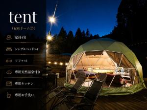 a tent with chairs in front of it at night at フォレスタ阿蘇車帰 in Aso