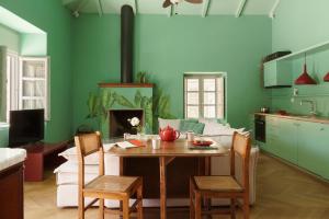 a kitchen with a table and chairs and a living room at Cactus Hydra - Art Apartments in Hydra