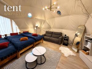 a bedroom with a tent with a bed and a couch at フォレスタ阿蘇車帰 in Aso +62 photos