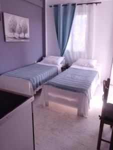 two beds sitting in a room with a window at Αλέξανδρος 4 in Myrina +5 photos