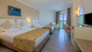 a hotel room with a bed and a television at Crystal Admiral Aqua Collection - Ultimate All Inclusive in Kızılot